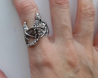 Op de afbeelding: Een zilveren drakenring met gedetailleerde vleugels en schubben.