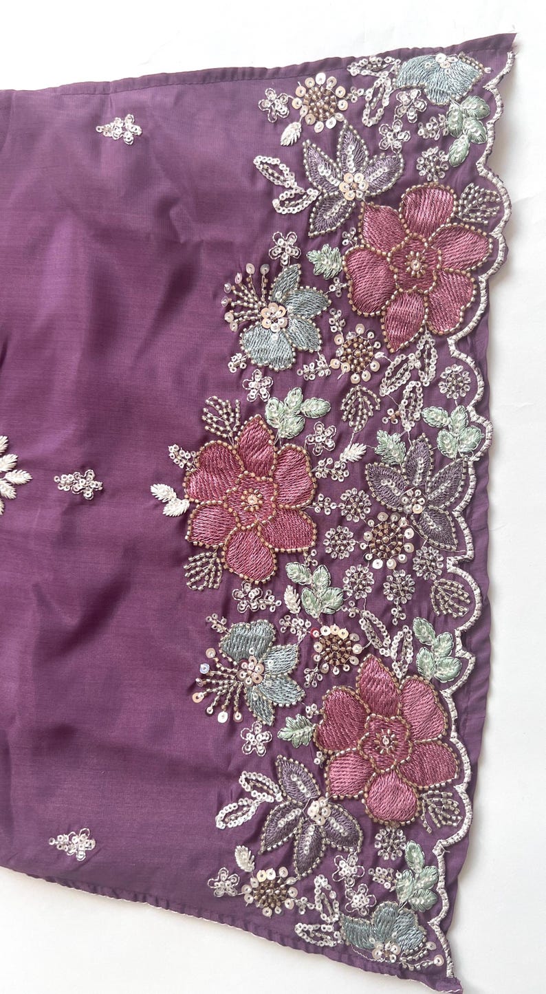 Puede incluir: Una tela de color morado intenso con un borde bordado intrincado con motivos florales en tonos rosa viejo, verde salvia y plata met&aacute;lica. El dise&ntilde;o incluye hilos detallados, peque&ntilde;as lentejuelas transparentes y cuentas en el borde festoneado.
