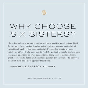 Pu&ograve; includere: Uno sfondo bianco con un logo dorato e testo che recita "WHY CHOOSE SIX SISTERS?"  Il testo sotto spiega che l'azienda progetta e crea gioielli di qualit&agrave; ereditaria dal 2006.  Il testo afferma anche che l'azienda utilizza materiali di origine etica e che &egrave; appassionata di creare tradizioni familiari durature.  Il testo termina con il nome della fondatrice, Michelle Emerson, e il sito web dell'azienda, www.sixsistersbeadworks.com.