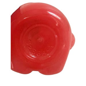May include: A bright red, circular glass object with a smooth, glossy finish. The base features embossed, molded text that is partially visible, showing the numbers 923647. The object has a rounded, uniform shape with a slightly raised center.