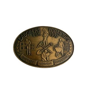May include: Bronze oval emblem with the text "LABORERS EST. LOCAL 1076 1937". The emblem features illustrations of construction workers using tools like a pickaxe, shovel, and wheelbarrow. The words "JUSTICE HONOR STRENGTH" are also present.