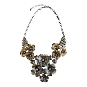 May include: A statement necklace featuring a cascade of metal flowers in silver and gold tones. The necklace has a chain with an adjustable clasp and decorative accents. The flowers are embellished with small, clear crystals.
