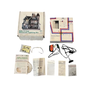 Könnte beinhalten: Ein Puppenhaus-Beleuchtungs-Set mit einer Box, die eine detaillierte Illustration eines Puppenhauses zeigt. Das Set enthält eine Übungsplatine, Kupferleiterband und andere Komponenten. Der Text "Safe 'N Easy Dollhouse Lighting Kit" ist sichtbar.