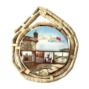 May include: A round souvenir featuring images of San Juan, Puerto Rico, with the text "San Juan Puerto Rico" and a Puerto Rican flag. The souvenir is set within a woven, light brown, circular frame with a handle.