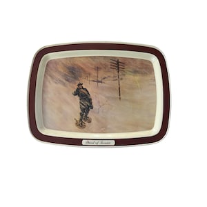 May include: A rectangular serving tray with a dark maroon border and a cream-colored inner rim. The center features an illustration of a person wearing snowshoes in a snowy landscape with utility poles. The text Spirit of Service is printed.