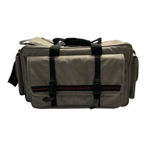 May include: A grey travel bag with multiple compartments and pockets. The bag has black straps and buckles, with a red stripe detail. It features a top handle and a shoulder strap. Designed for travel and storage, it is rectangular in shape.