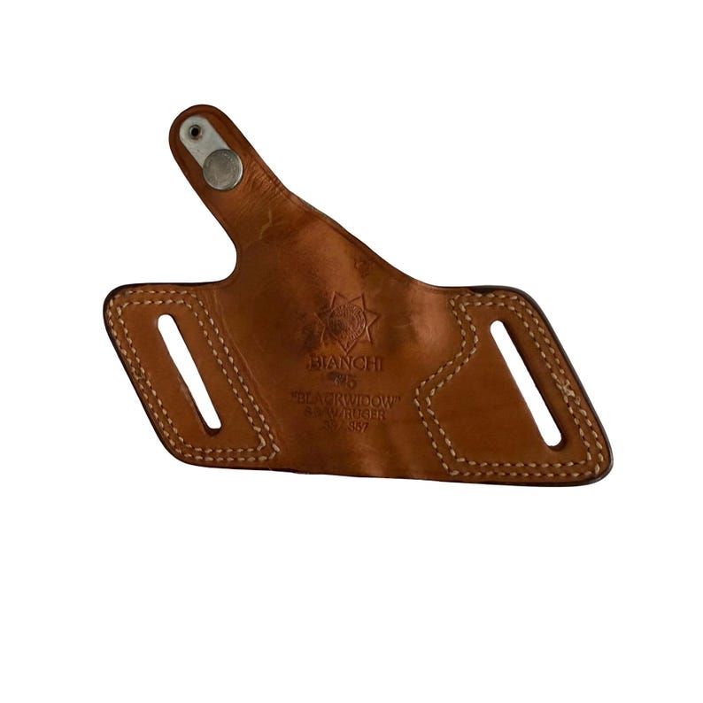 Puede incluir: Una funda de cuero marr&oacute;n con costuras blancas y un broche met&aacute;lico. La funda tiene dos ranuras y el texto "BIANCHI PROS BLACKWIDOW S&W RUGER 33-557". La funda est&aacute; dise&ntilde;ada para sujetar un arma de fuego.