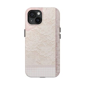 Peut inclure: Coque de téléphone ornée d'une dentelle florale crème et rose pâle. L'étui a une esthétique douce et féminine, avec un motif vichy en bas et une bordure rose uni. Les lentilles de la caméra sont visibles en haut.