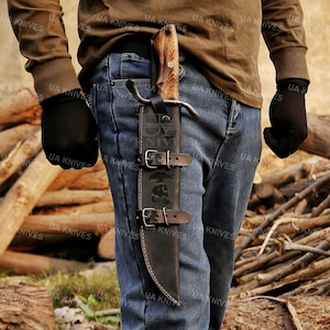 May include: A white ceramic mug with a black handle and the text "But First, Coffee" in a black, handwritten-style font. The mug is on a white surface.
