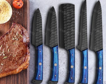 May include: A set of six black chef knives with textured blades and blue handles. The handles have gold-colored rivets. The knives are displayed on a wooden cutting board next to a steak, tomato, and onion.