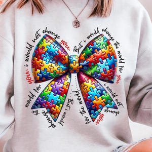 May include: A white sweatshirt with a colorful puzzle piece bow and the text "you. i would not change the world for you. But i would change the world for you. But i would not change you."