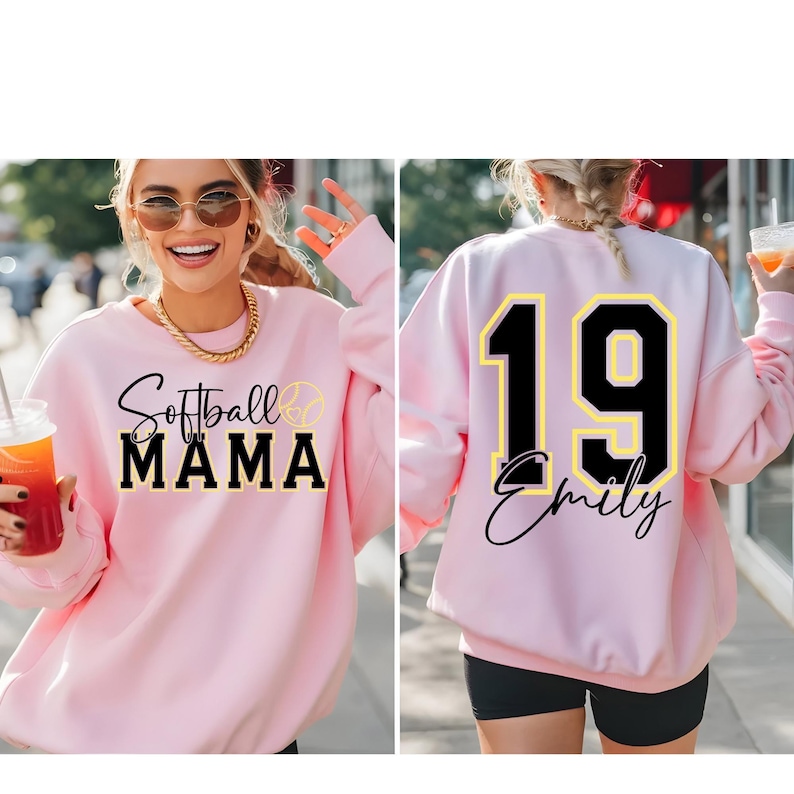 May include: Pink sweatshirt with the text "Softball Mama" and a softball graphic on the front. The back of the sweatshirt has a black number "19" with a yellow outline and the name "Emily" written underneath.