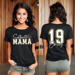 May include: Black t-shirt with the text "Softball Mama" and a softball graphic on the front. The back of the shirt has a white number "19" with a yellow outline and the name "Emily" written in cursive below the number.