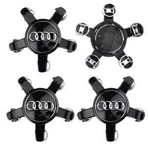 May include: Four black wheel center caps with the Audi logo in silver. Each cap has a five-spoke design with silver accents on the ends of each spoke. The caps are glossy and appear new.