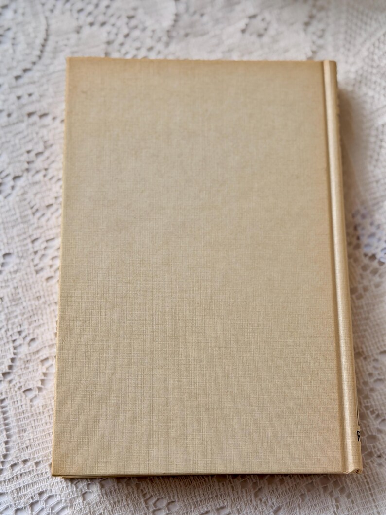 Peut inclure: Un livre &agrave; couverture rigide avec une couverture et un dos beiges. La couverture a un aspect textur&eacute;. Le livre est rectangulaire et semble ferm&eacute;. Le dos est d'une teinte beige plus claire.