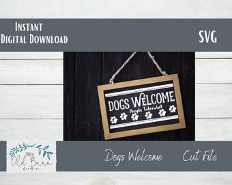 May include: A black chalkboard sign with white text that reads "Dogs Welcome People Tolerated" with paw prints. The sign is hanging from a white rope on a black wooden background.