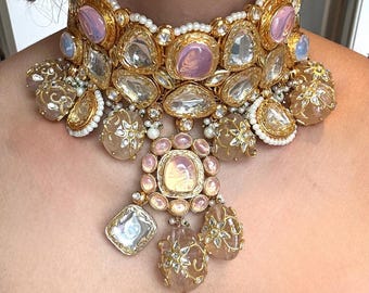 Può includere: Un collier choker in oro e argento con pietre preziose rosa e trasparenti. Il collier ha un grande ciondolo centrale con una pietra preziosa rosa e ciondoli più piccoli con pietre preziose trasparenti.