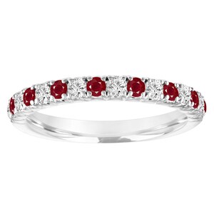 May include: A delicate silver band ring with a row of alternating red rubies and white diamonds.