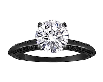 May include: A black engagement ring with a large, round, clear diamond set in a black metal band. The band is accented with small black diamonds.