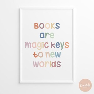 Może przedstawiać: Biały wydruk w ramie z tekstem "BOOKS are magic keys to new worlds" w kolorowych, zaokrąglonych literach. Tekst jest w pastelowej palecie kolorów.