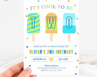 May include: A birthday invitation with the text "IT'S COOL TO BE TWO" above three popsicle illustrations. The invitation includes the text "join us for a sweet time for OLIVER'S 2ND BIRTHDAY" and event details. The invitation is held by a hand.