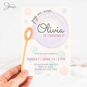 Puede incluir: Invitación de fiesta de cumpleaños con tema de burbujas. La invitación presenta el nombre "Olivia" y el texto "IS TURNING 2". La invitación también incluye la fecha, la hora y la información de RSVP.