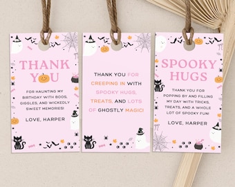 May include: Three pink Halloween-themed gift tags with brown twine. Each tag features a different message in pink and black, with illustrations of ghosts, cats, and pumpkins. The tags say "Thank You" and "Spooky Hugs".