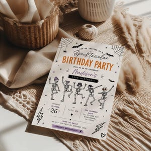 A Halloween-themed birthday party invitation featuring skeletons dancing and a spider web design.