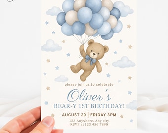 May include: A light beige birthday invitation featuring a teddy bear holding onto a bunch of blue and beige balloons. The text reads "Oliver's BEAR-Y 1ST BIRTHDAY!" with date, time, and RSVP information.