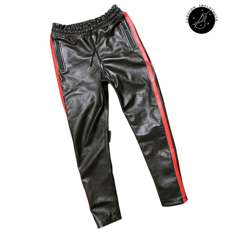 May include: Black faux leather pants with a red stripe down the side. The pants have an elastic waistband with a drawstring. The pants have two pockets and a logo on the upper right side.