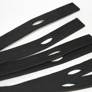 May include: Six black fabric straps with a small oval-shaped hole cut out of each strap.