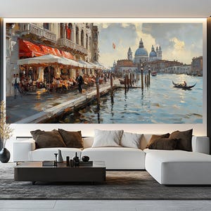 Può includere: Grande dipinto a olio raffigurante una scena del canale veneziano con un ristorante, una gondola e edifici a cupola. L'opera presenta una tenda rossa, ombrelloni bianchi e figure lungo la riva. Il dipinto è esposto sopra un divano bianco e un tavolino scuro.
