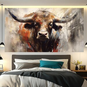 May include: A large canvas art print of a bull's head, painted in a modern, abstract style. The artwork features a close-up of the bull's face with prominent horns, rendered in shades of brown, orange, and gray. The painting is displayed above a bed.
