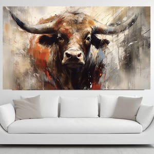 May include: A large canvas print of a bull's head, painted in an abstract style. The artwork features a brown bull with large horns, set against a backdrop of beige, gray, and orange brushstrokes. The bull's face is the focal point.
