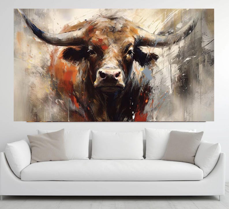 May include: A large canvas print of a bull's head, painted in an abstract style. The artwork features a brown bull with large horns, set against a backdrop of beige, gray, and orange brushstrokes. The bull's face is the focal point.