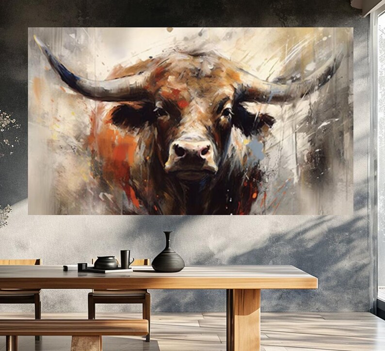 May include: A large canvas print of a bull's head, rendered in an abstract style with brown, orange, and gray tones. The artwork features a detailed depiction of the bull's face and horns, with brushstrokes creating a textured effect. The print is displayed above a wooden dining table.