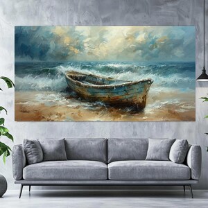 May include: An oil painting depicts a weathered blue boat on a sandy beach, with foamy waves crashing around it. The sky is filled with dramatic clouds, and the overall color palette is dominated by blues, browns, and whites. The artwork is displayed above a gray sofa.