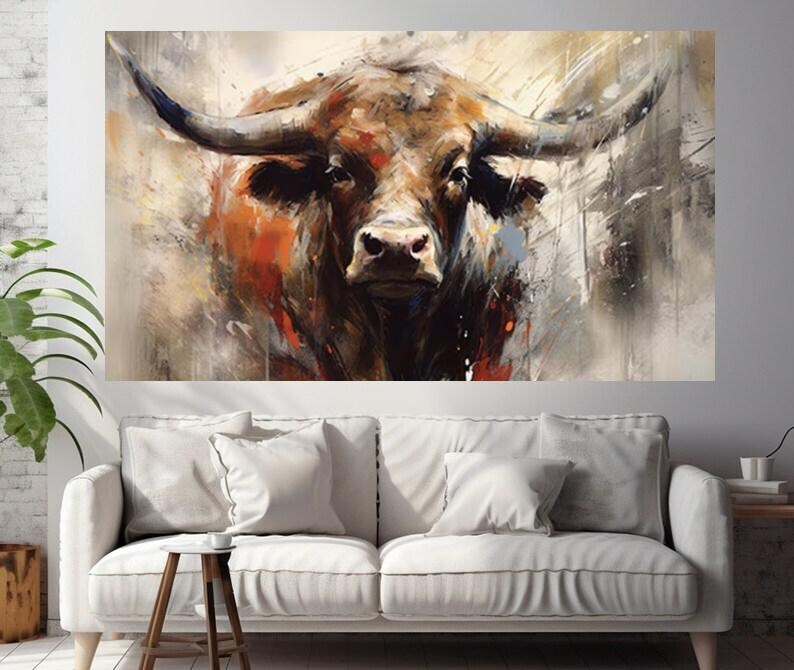 May include: A large canvas print of a bull's head, rendered in an abstract style with a focus on texture and color. The artwork features a palette of browns, oranges, and grays, with visible brushstrokes. The bull's horns are prominent, and the overall effect is bold and expressive.