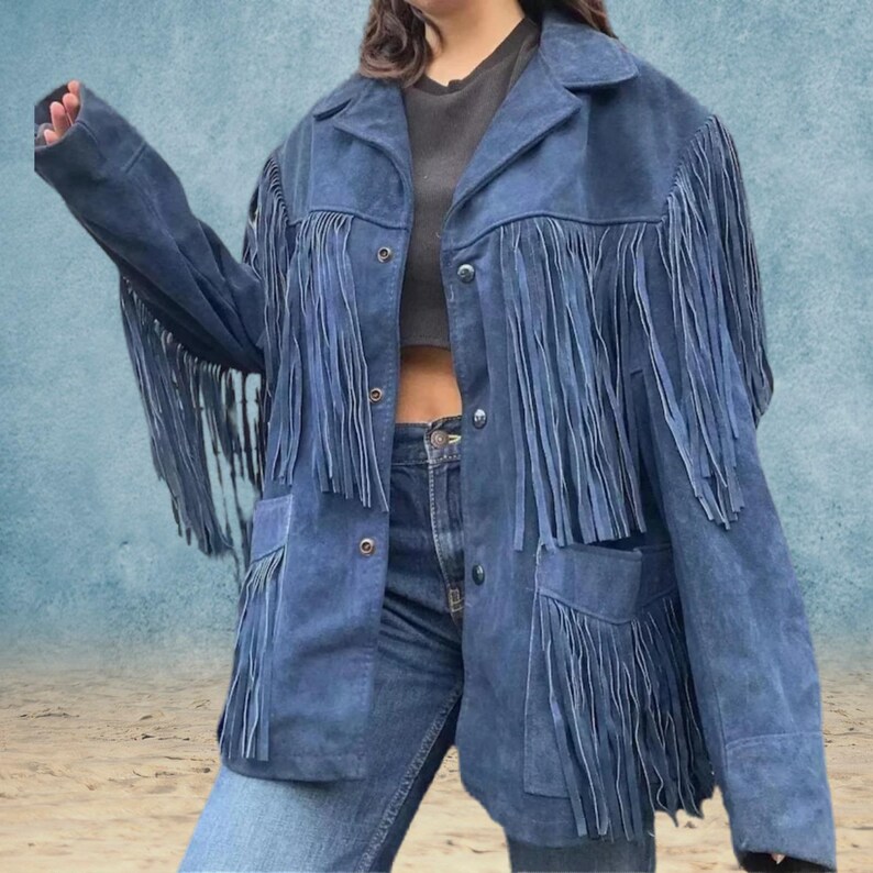 Peut inclure: Une veste en jean bleu avec des d&eacute;tails en franges. La veste a une fermeture boutonn&eacute;e &agrave; l'avant et deux poches.