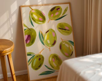 May include: A framed art print featuring a pattern of green olives with pink accents and green leaves on a cream background. The artwork is displayed in a light brown wooden frame, leaning against a wall.