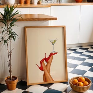 Martini print with red heels placed on the floor of a white kitchen with checker tile. Surrounded by greenery and oranges, creating a chic, fresh look.