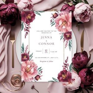 Puede incluir: Invitación de boda con diseños florales en acuarela en tonos burdeos y rosa. La invitación incluye los nombres "Jenna & Connor", fecha, hora y dirección. Cubiertos dorados y arreglos florales rodean la invitación.