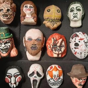 May include: A collection of eleven hand-painted horror movie character figurines. The figurines include characters like Freddy Krueger, Chucky, and Jason Voorhees. Each figurine is uniquely designed with distinct facial features and colors.