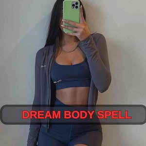 May include: A gray zip-up jacket, a navy blue sports bra, and matching shorts. The outfit is worn with a gold necklace. The text "DREAM BODY SPELL" is displayed in a red box at the bottom of the image.