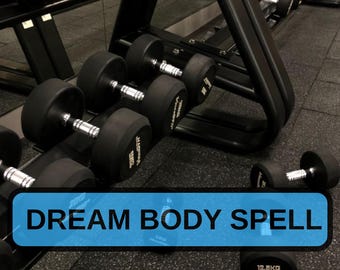 May include: Black dumbbells of varying weights are arranged on a rack in a gym setting. The text "DREAM BODY SPELL" is displayed on a blue rectangular banner. The dumbbells have black rubber-coated heads and silver handles.