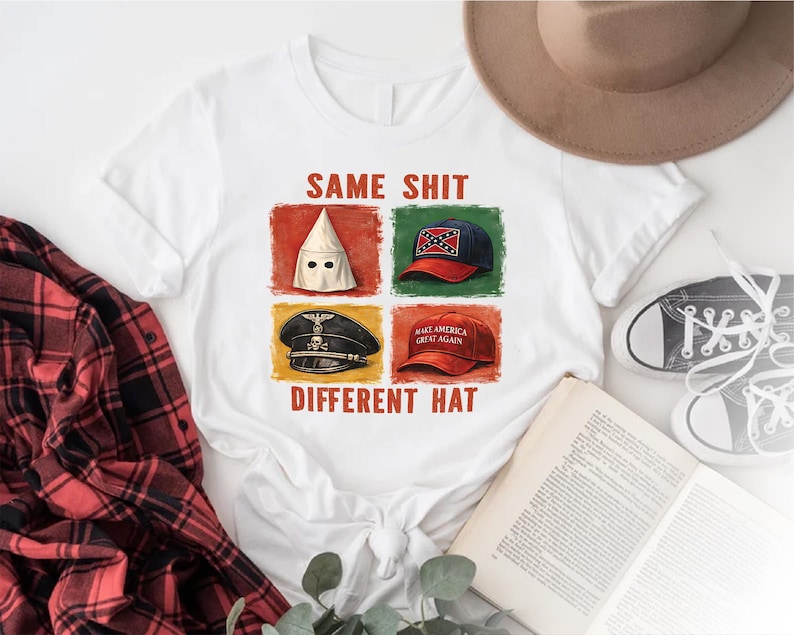 May include: White t-shirt with the text "SAME SHIT DIFFERENT HAT" and four images of hats: a white hood, a Confederate flag baseball cap, a Nazi cap, and a "Make America Great Again" hat. A red and black plaid shirt is visible.