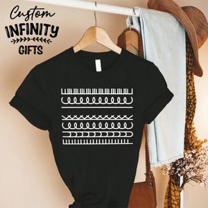 May include: Black t-shirt with a white graphic design featuring various line patterns. The shirt also has the text "Custom Infinity Gifts" in a stylized font.