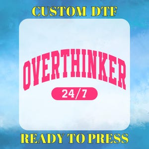May include: A white square with a pink graphic that says "Overthinker" in a collegiate font. The graphic is arched and has a smaller pink rectangle underneath that says "24/7". The text "CUSTOM DTF" is in yellow at the top of the square and "READY TO PRESS" is in yellow at the bottom.