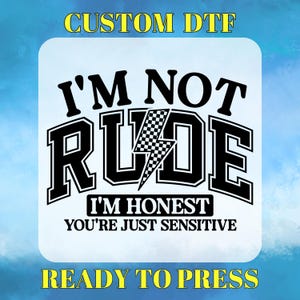 May include: Black and white iron-on transfer design with the text "I'm not rude, I'm honest, you're just sensitive" with a checkered flag and lightning bolt graphic. The text "Custom DTF" and "Ready to Press" are also included.