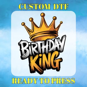 May include: A graphic design with a gold crown above the words "BIRTHDAY KING" in black and orange, with the text "CUSTOM DTF" and "READY TO PRESS" in yellow. The design is set against a light blue background.